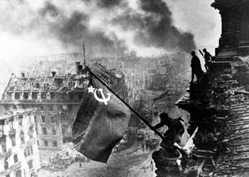 Soviet troops hoist the red hammer and sickle flag over the Reichstag in Berlin